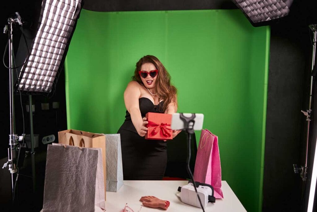 Frau steht vor einer selbstgemachten DIY-Fotobox und posiert lachend für ein Erinnerungsfoto bei einer Hochzeit in der Schweiz.