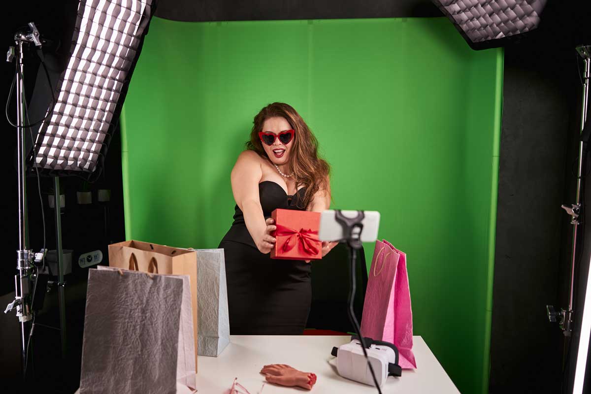 Frau steht vor einer selbstgemachten DIY-Fotobox und posiert lachend für ein Erinnerungsfoto bei einer Hochzeit in der Schweiz.